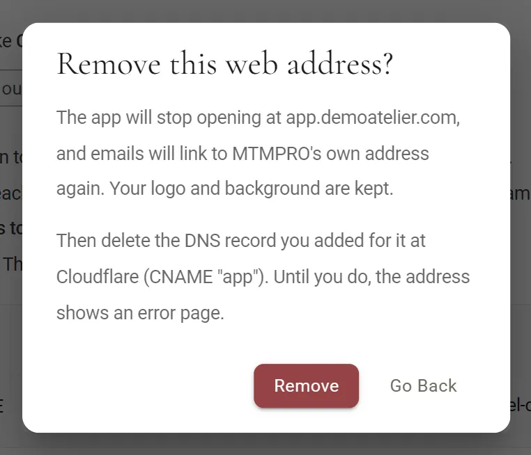 The Remove this web address? dialog. It says the app will stop opening at app.demoatelier.com and emails will link to MTMPRO's own address again, that the logo and background are kept, and then to delete the DNS record you added at Cloudflare (CNAME app), because until you do the address shows an error page. Remove and Go Back buttons.